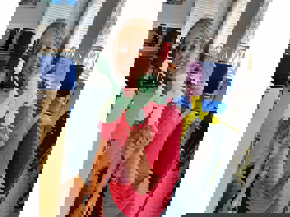 Girl smiling holding balloon animal