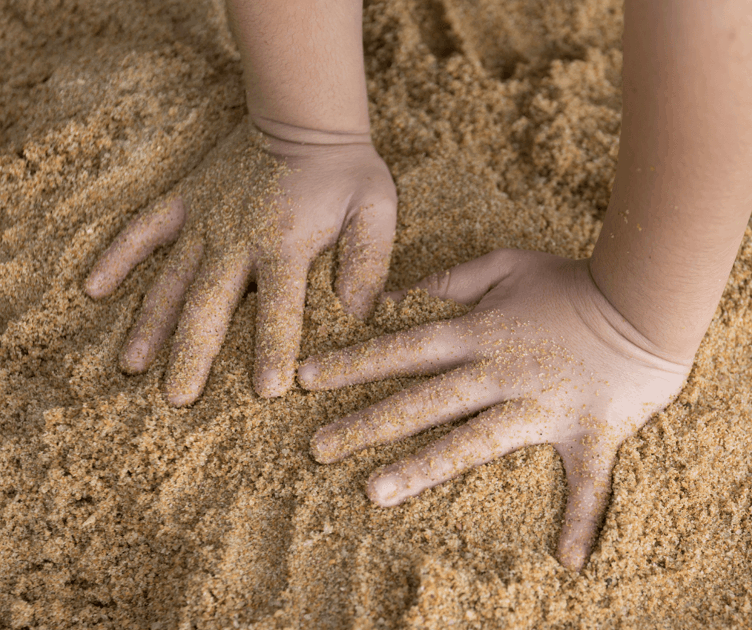 Children's hands in sand