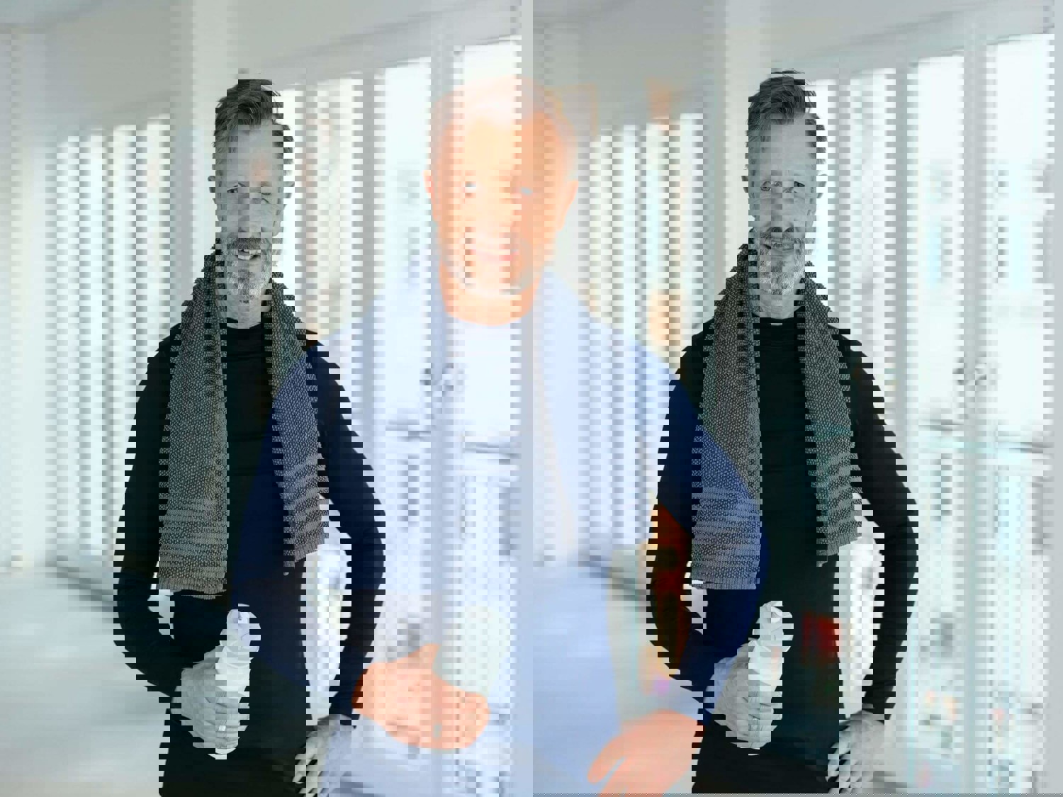 Man with towel around shoulders holding a water bottle