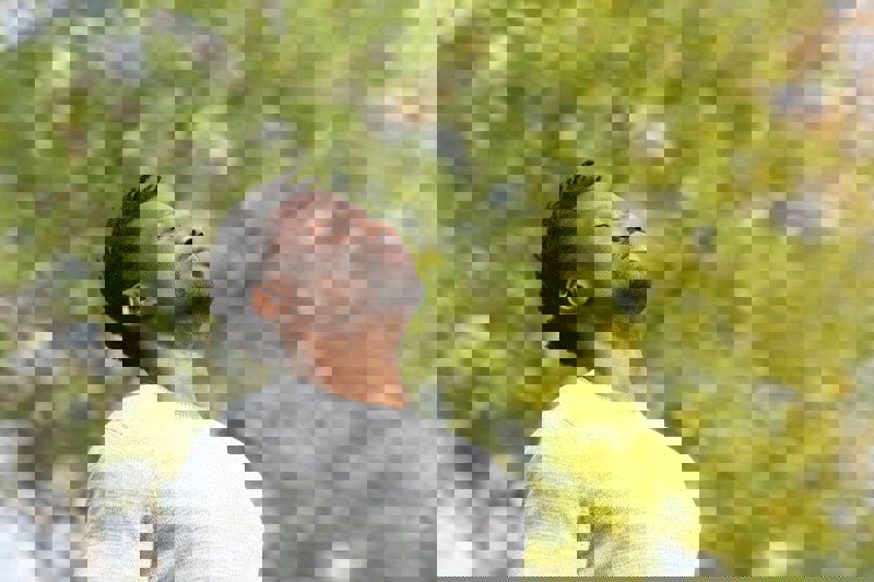 Man looking up to sky with eyes closed