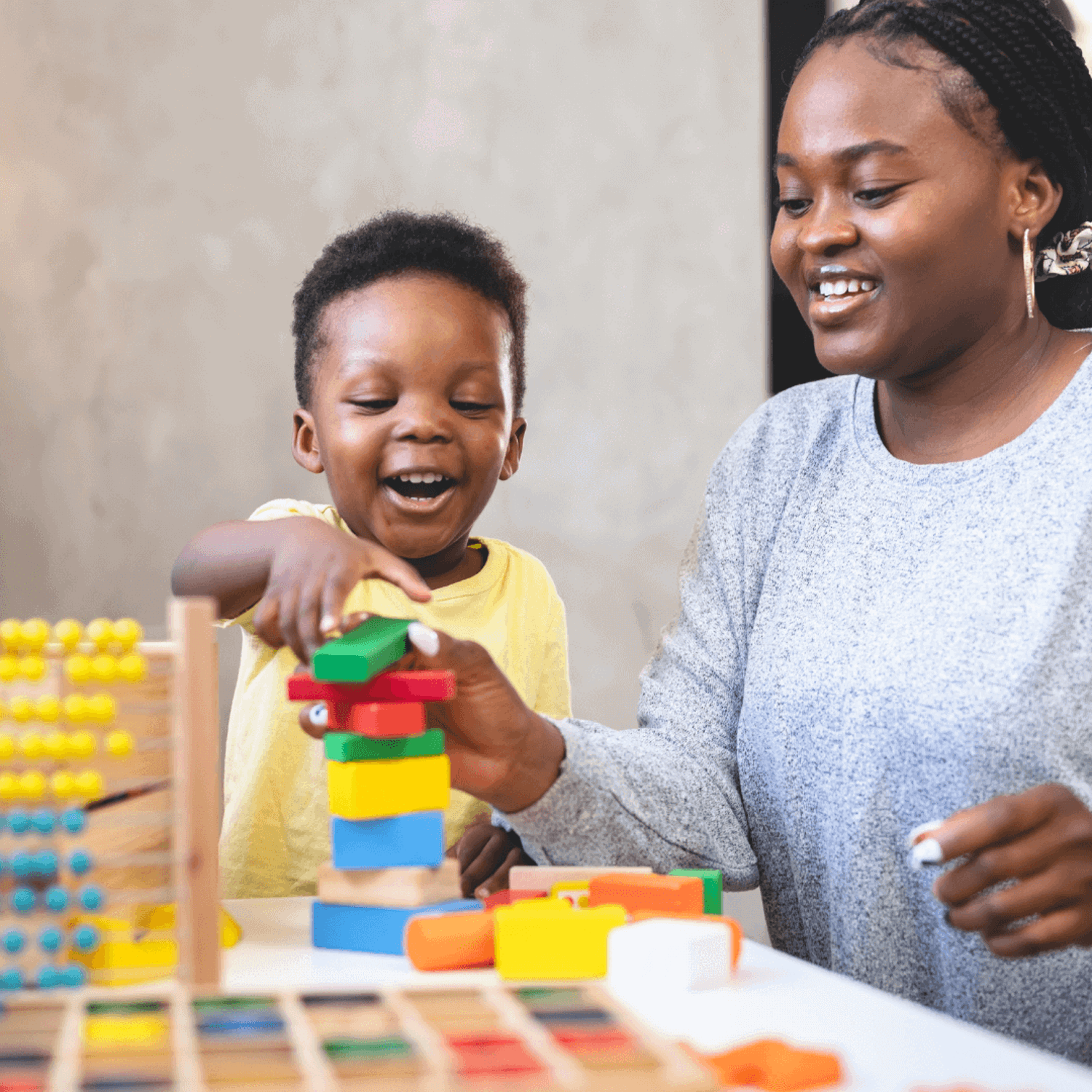 Woman and boy counting stacking bricks
