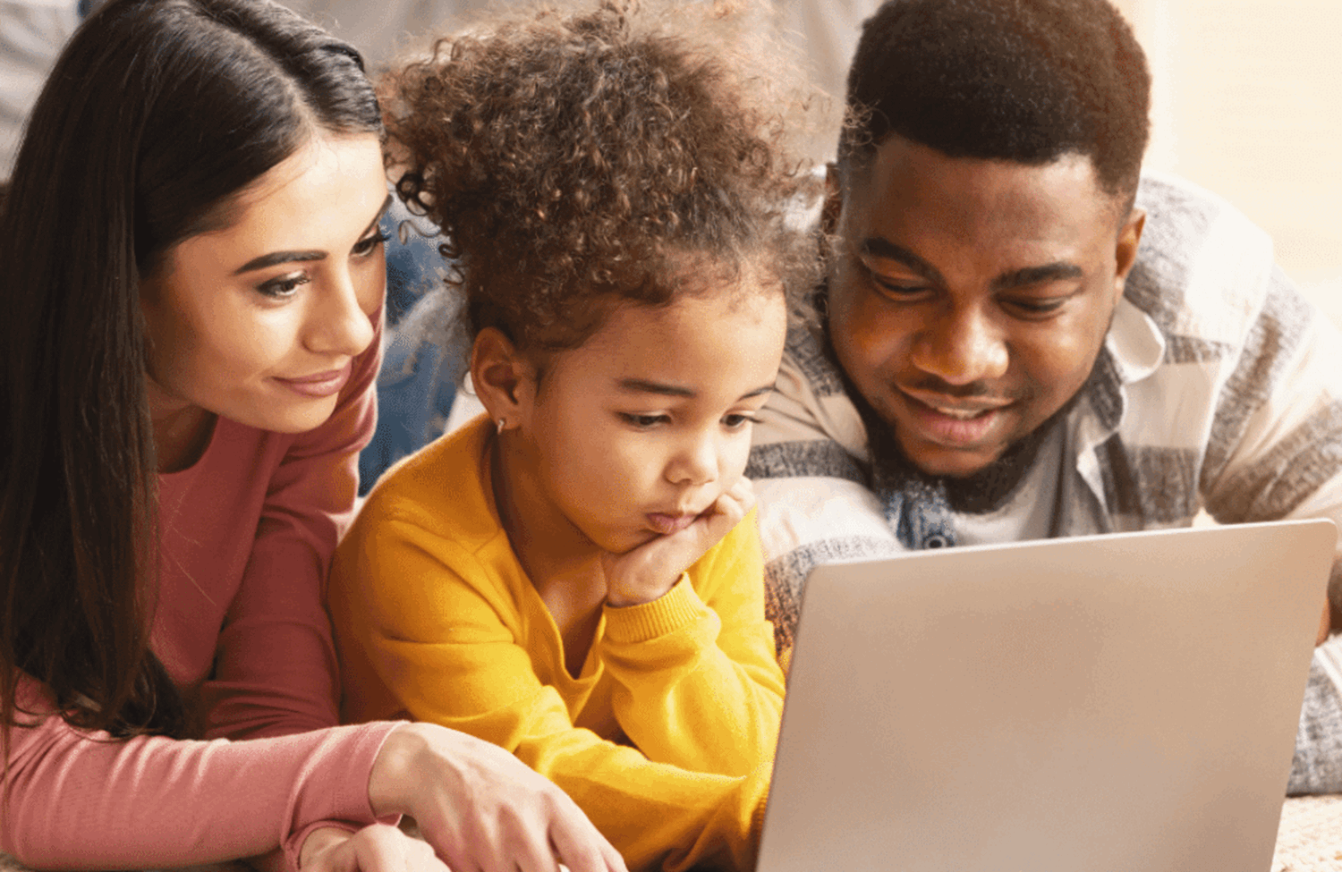 Parents and child looking at a laptop together