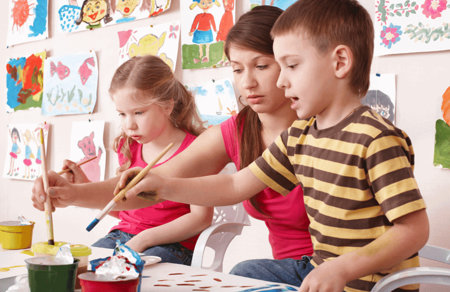 Children and adult painting together