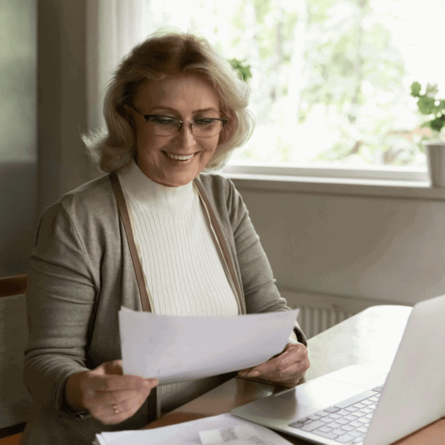 Lady at laptop holding paper