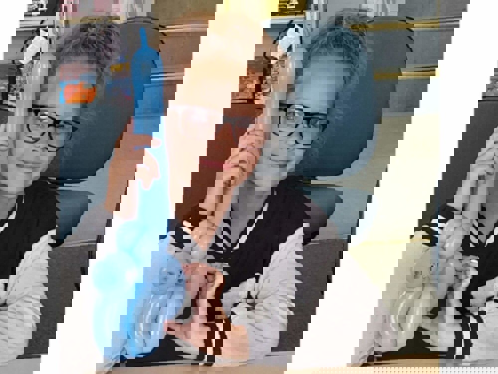 Girl smiling holding balloon animal