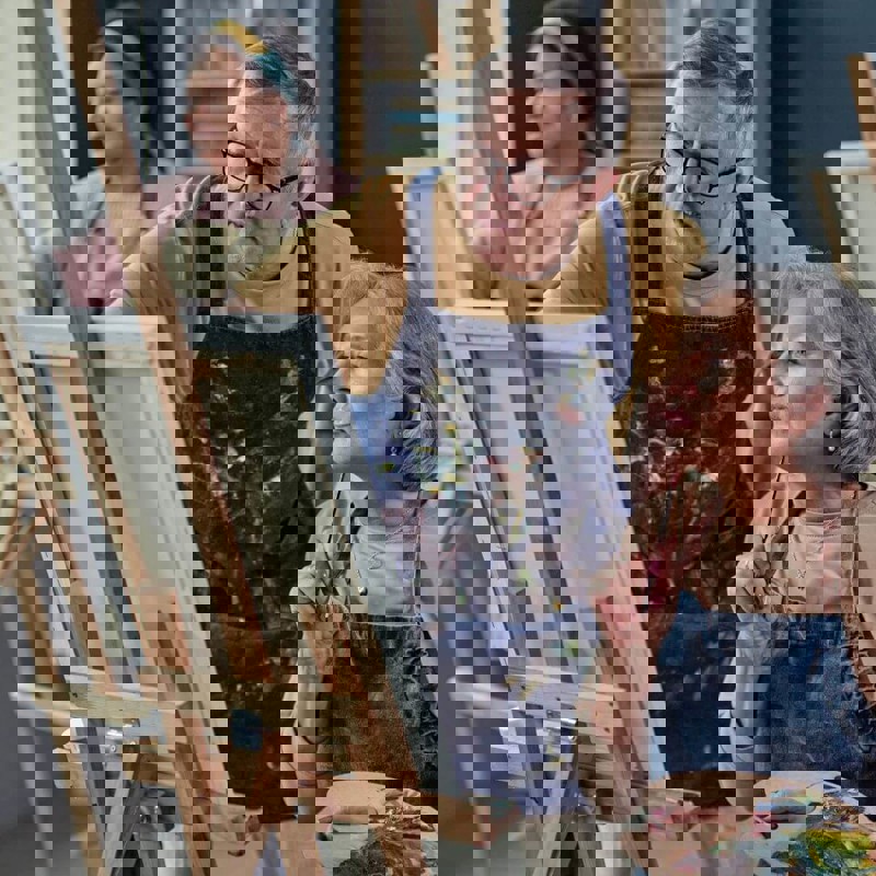 Two people working on an artist easel