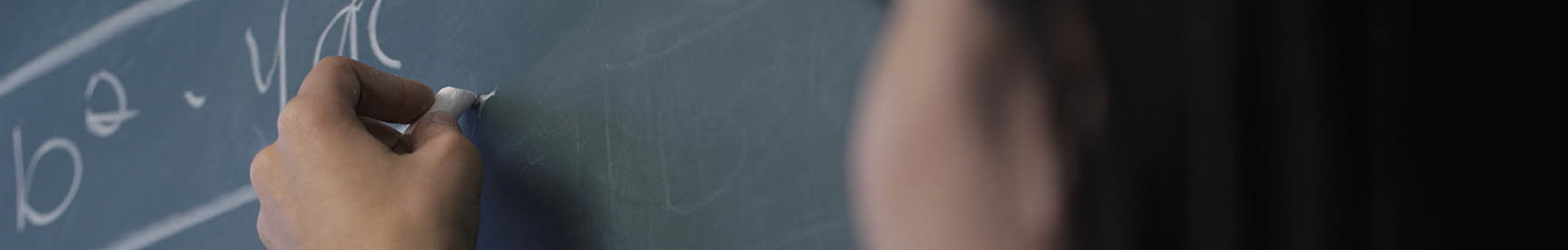 Woman writing with chalk on a chalkboard