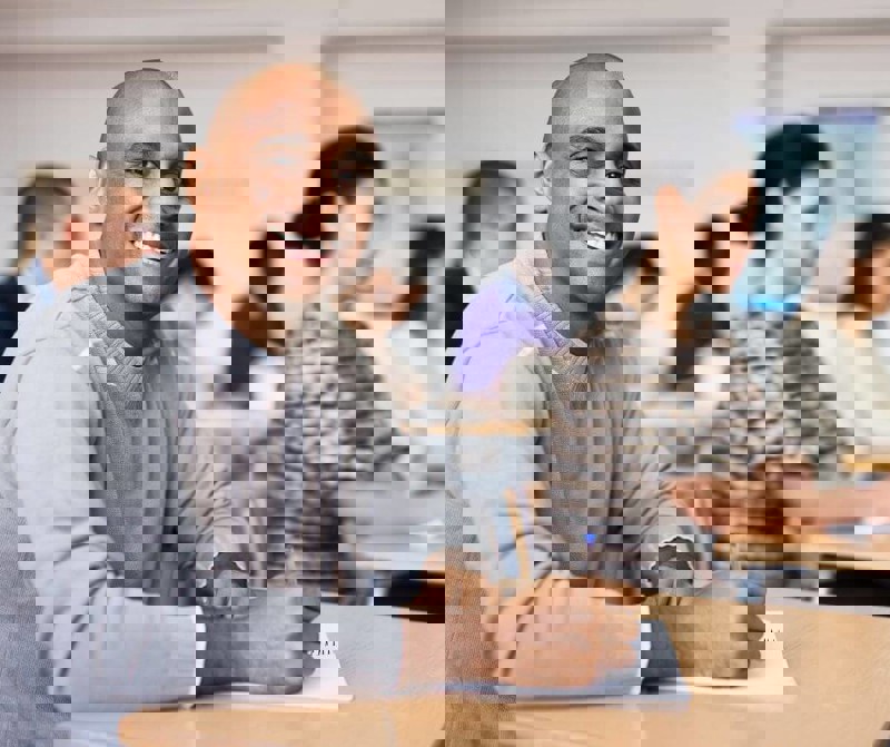 Two people sitting at a table looking at a book