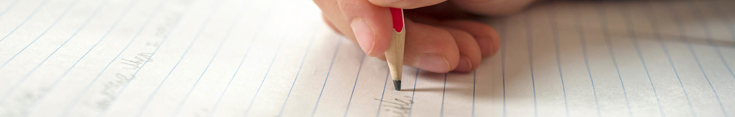 Writing on lined paper with a pencil
