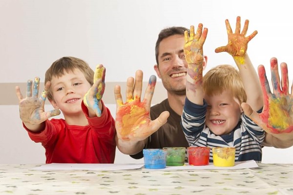 Children and father with paint on hands