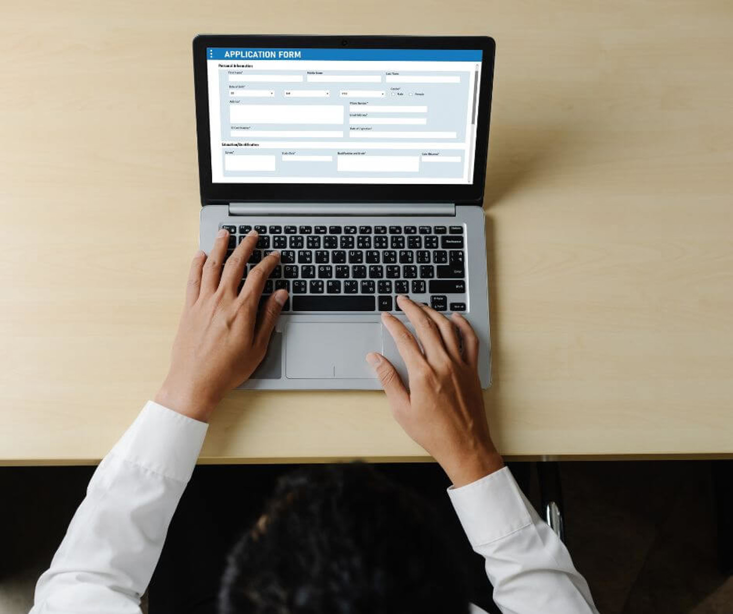 Hands typing on an open laptop